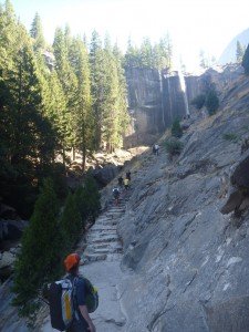 Mikey's looking up a steep staircase wearing a duffel bag "backpack" on his back and a 20L daypack on his front.