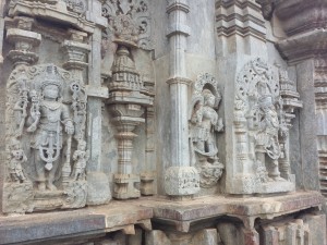 The stone edifice shown is a temple with an incredible amount of carvings on it. There are many deities and details carved into the walls.