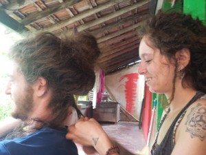 V is sitting behind Mikey manipulating his hair into dreadlocks.