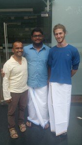 Mikey is dressed in a traditional Dhoti for Sadhya, smiling as he stands next to 2 others