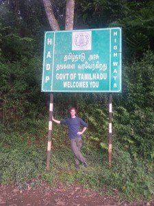 Mikey stands under a sign that reads "Govt of Tamil Nadu Welcomes You"