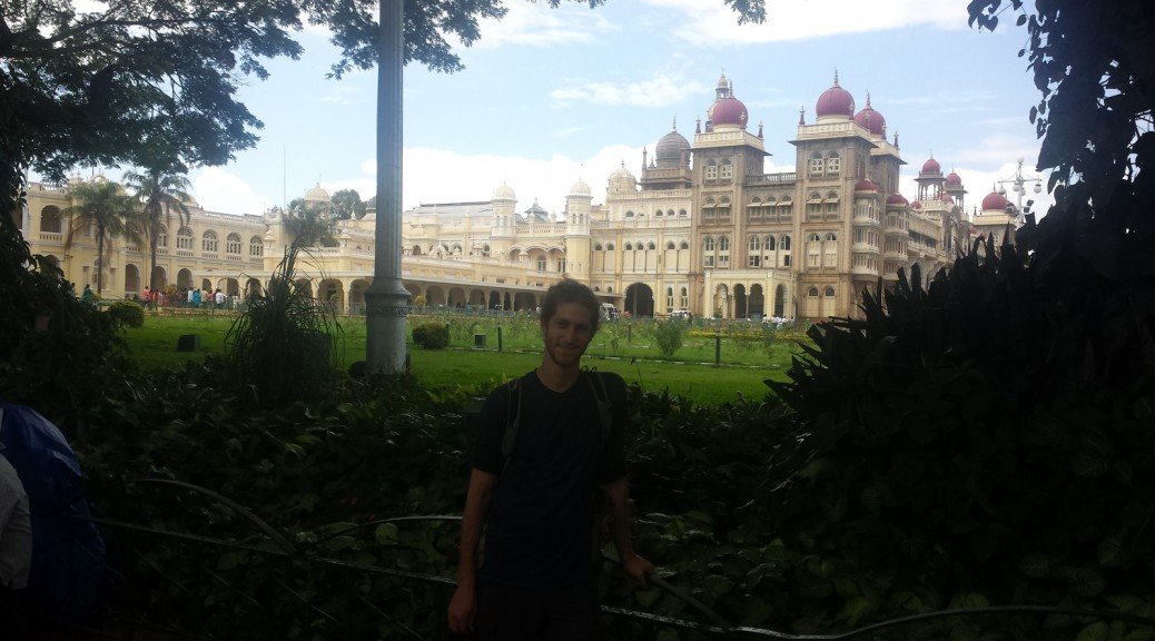 Mikey stands in front of a palace in Mysore