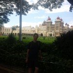 Mikey stands in front of a palace in Mysore