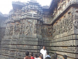 The stone edifice shown is a temple with an incredible amount of carvings on it. There are many deities and details carved into the walls.