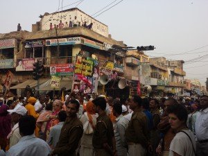 A crowd of people fill a street celebrating Krishna.