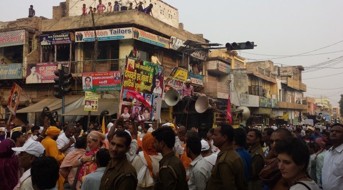 A crowd of people fill a street celebrating Krishna.