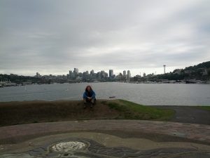 Mikey sits on a hill at Gas Works Park overlooking the PUget Sound and the Seattle Skyline