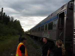 train conductors, staff, and passengers stand next to old train in the middle of nowhere, Canada