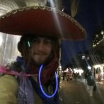 Mikey at Marti Gras in New Orleans sporting a sombreo, glostics, and colorful bandanas tied in his dreadlocks