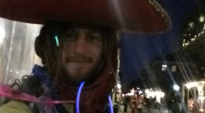 Mikey at Marti Gras in New Orleans sporting a sombreo, glostics, and colorful bandanas tied in his dreadlocks