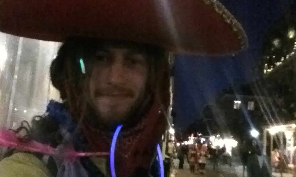 Mikey at Marti Gras in New Orleans sporting a sombreo, glostics, and colorful bandanas tied in his dreadlocks