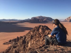 Mikey sits atop a sandstone mounain overlooking their bedouin camp in Wadi Rum