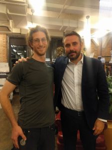 Mikey is shown in a selfie smiling next to Jeremy Scahill
