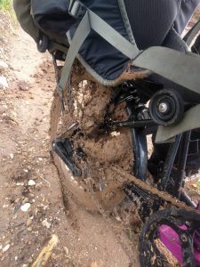 Mikey's bicycle's rear tyre is caked with mud.